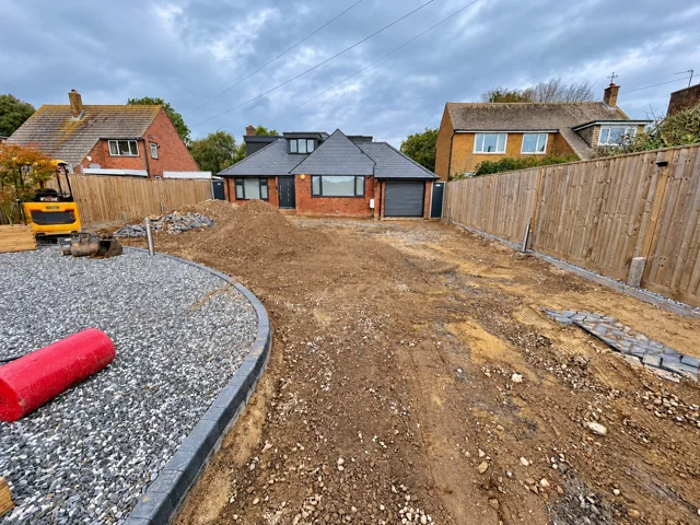 Wide view of the excavated driveway and curved gravel border